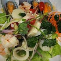11. Yum Seafood Salad · Shrimp, squid and scallop splashed with lime, chili, Thai sauce, mint and onion topped with ...