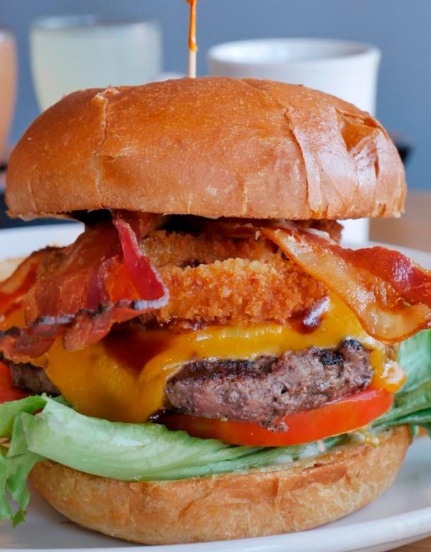 Wild West Burger · Ground beef patty, applewood bacon, onion rings, BBQ sauce, cheddar cheese, lettuce, tomato and mayo.