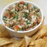 Ceviche of White Fish · Marinated in lime juice with tomato, red onion, cilantro.  Served with tortilla chips.