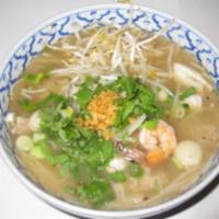 47. Combination Seafood Pho · A large bowl of rice noodles soup with a rare slice of steak, well-done steak, meatball and ...