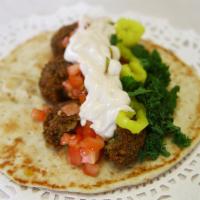8. Falafel Sandwich · Tomato, lettuce, mint, pickle and our sauce. Wrapped in pita bread.
