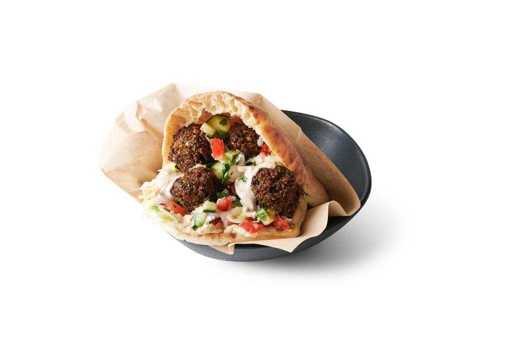 Falafel Pita · Freshly baked pita pocket stuffed with your choice of falafel, hummus, Israeli salad, pickled cabbage & creamy tahini sauce. Add toppings to customize it!