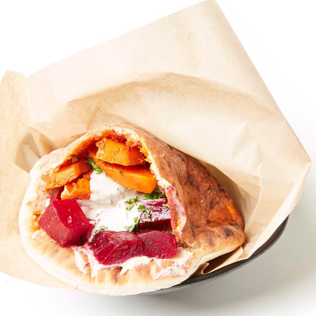 Beets & Carrots Pita · Freshly baked pita pocket stuffed with Moroccan carrots, marinated beets, hummus, israeli salad, pickled cabbage and creamy tahini sauce.  Add toppings to customize it!
