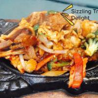 S22. Sizzling Triple Delight · Sauteed sliced beef, chicken and pork with fresh vegetables in satay sauce, served on a hot ...