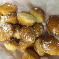 Honey Bites · Fresh dough bites flash fried and drizzled with honey then topped with powered sugar.