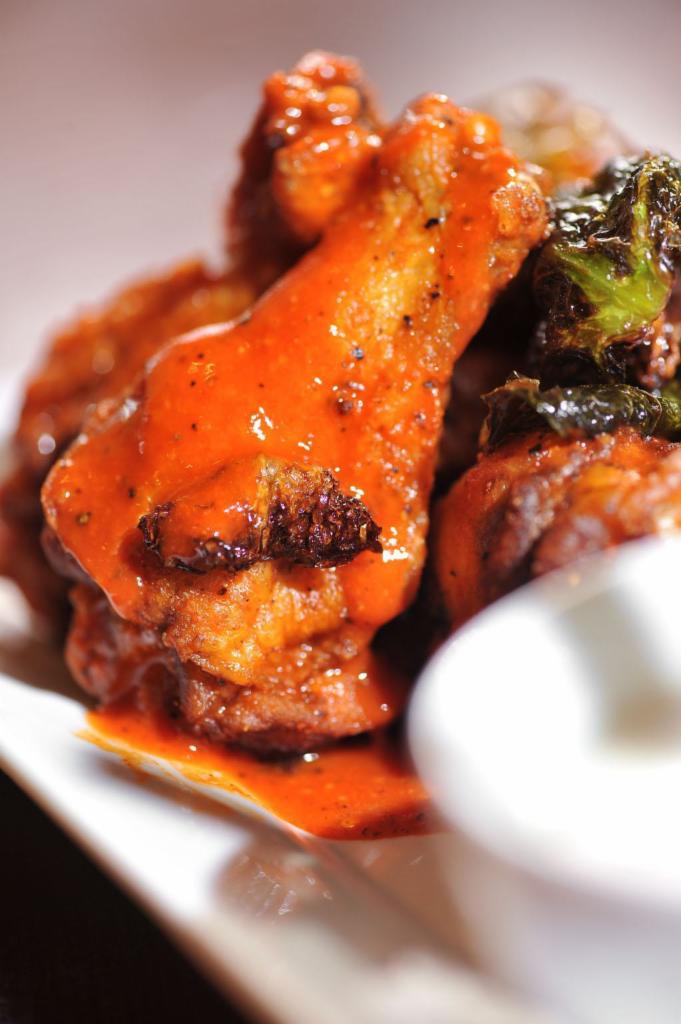 Colossal Chicken Wings · Our giant crispy chicken wings, tossed with traditional spicy/ butter buffalo sauce served with homemade yogurt-ranch dressing,  celery & carrot sticks