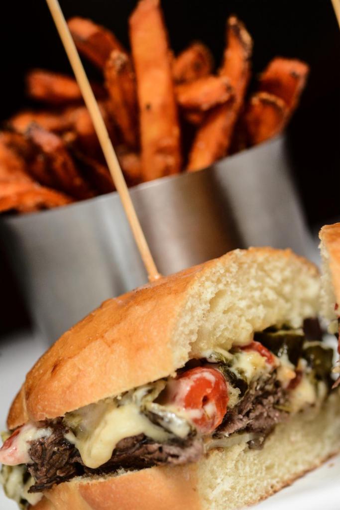 Rajas Con Queso y Carne Asada Sandwich · Pan de yema bread, sliced prime skirt steak, melted manchego cheese sauce, roasted poblanos, pimento peppers and grilled onions.