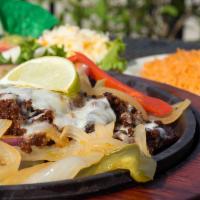 Fajitas Flameadas · Beef or chicken fajitas on a bed of grilled onions. Topped with chorizo and Monterey Jack ch...