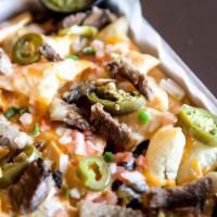 Smokehouse Nachos · Crispy tortilla chips layered with melted cheddar cheese and piled high with house-smoked br...