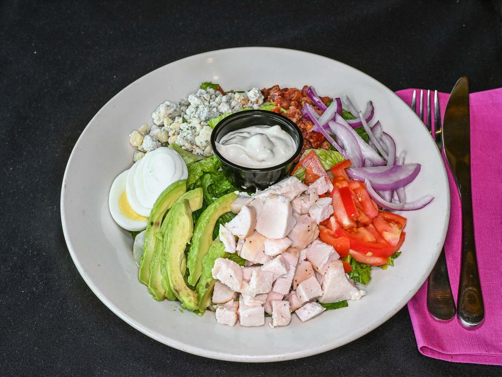 Cobb Salad · Hard-boiled egg, avocado, tomatoes, chicken, onion, bacon, bleu cheese dressing, and romaine lettuce.