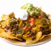 Nachos · Corn tortilla chips topped with beans, cheese, choice of meat, pico de gallo, guacamole, and...