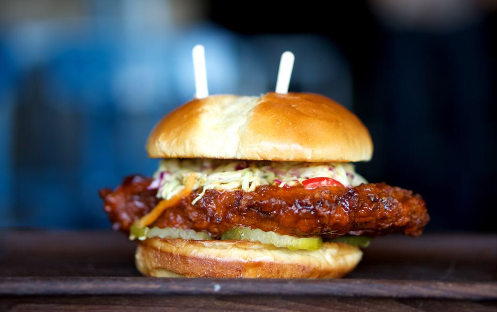 Hot Chicken Sandwich · Pickle brined fried chicken breast, Louisiana hot sauce, pickle chips, and honey mustard slaw. Choice of hot or extra hot.