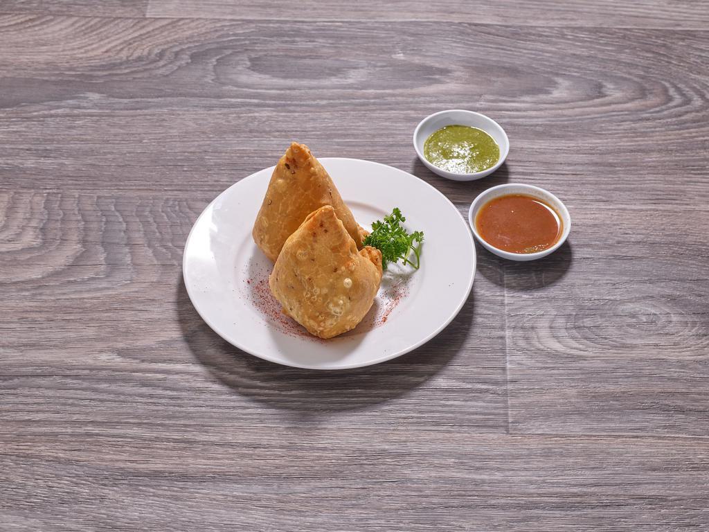 Spinach Samosa · Fried triangular dough stuffed with spinach, potato, green peas and cilantro seeds. Served with tamarind sauce. Vegan.