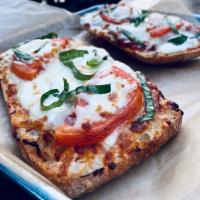 Margherita Pizza · Fresh mozzarella, tomato, fresh basil, shredded mozzarella and red sauce.