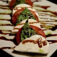 Caprese Salad · Cherry tomatoes, fresh mozzarella ciliegine, basil, olive oil and balsamic.