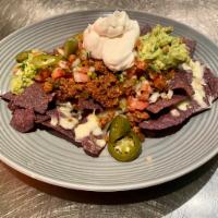 NACHOS · ground beef, jalapeno, chopped tomatoes, onions, cilantro, beer cheese sauce (cheddar, parme...