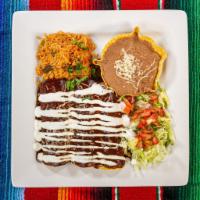 Enchiladas Poblanos · Hand wrapped in a fresh corn tortilla, filled with shredded chicken, topped with mole poblan...