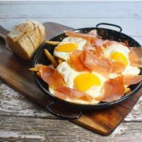 Huevos Estrellados · A very typical spanish dish with french fries topped with three fried eggs and serrano ham o...