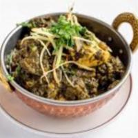 Saag Chicken · Boneless cubes of chicken simmered in spinach sauce served with a side of Basmati Rice.