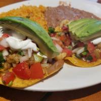 Tostadas · 2 crisp flat corn tortillas topped with beans, lettuce, sour cream, chihuahua cheese and pic...