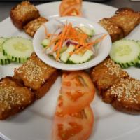 Thai Toast · Crispy toast topped with minced chicken and shrimp. Served with cucumber salad.