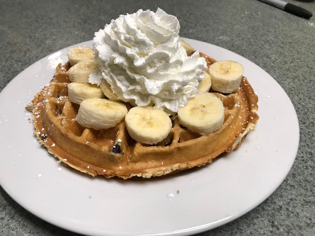 Blueberry Wafle · Homemade Belgian wafle filled with blueberry. Topped with fresh banana and whipped cream. Served with butter and syrup.