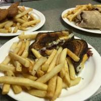 Grilled Reuben Sandwich & fries · Corned beef, thousand island, Sauerkraut, and Swiss cheese on rye. Served with fries.