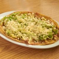 Huarache Sencillo · Topped with onions, lettuce, cheese, salsa, and beans.