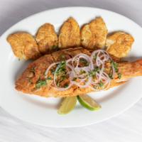 Pargo Frito · Marinated Caribbean red snapper, fried golden, topped with red onions and served with lime.