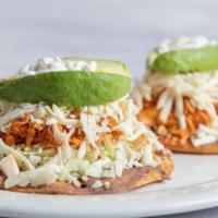 Tostadas con Tinga · Crisp corn tortillas topped with refried beans, shredded chicken in a chipotle sauce, shredd...