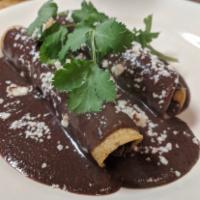 Kid's Chicken Taquitos · 2 chicken taquitos covered with black bean and topped with queso fresco.