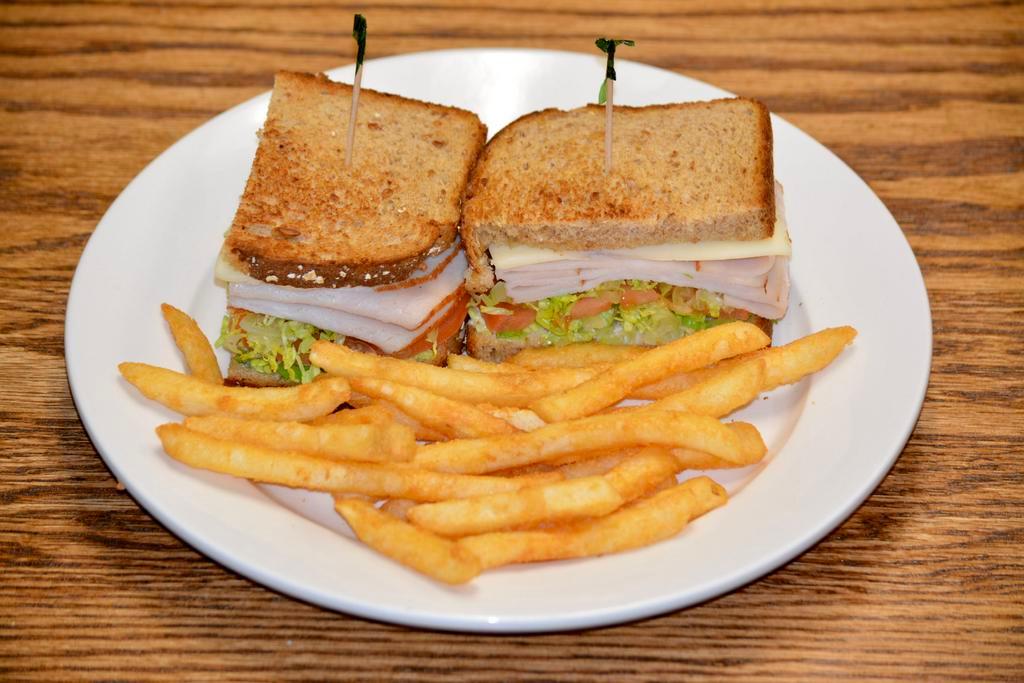 Smoked Turkey Club Sandwich · Smoked turkey, lettuce, tomatoes, and provolone cheese on multigrain bread with crispy fries.