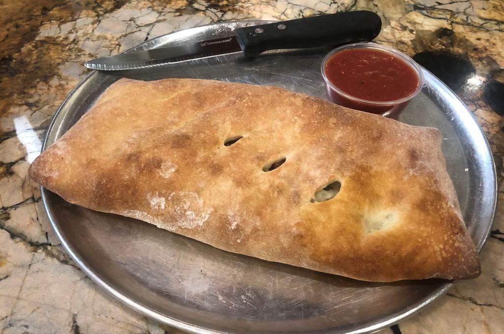 Veggie Stromboli · Mushrooms, spinach, onions, peppers, black olives, tomatoes, banana peppers and Mozzarella cheese. Includes a side of Marinara sauce.