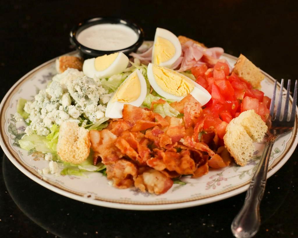 Charlies Cob Salad · Lettuce, bacon, tomato, hard boiled egg, diced ham blue cheese crumbles and ranch dressing.