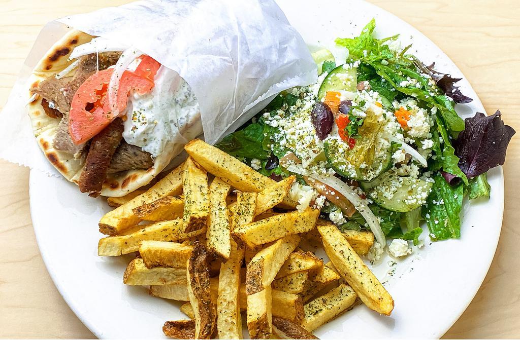 Gyro Combo · Tender gyro slices served on pita bread, dressed with tomato, onion & tzatziki sauce with hand cut Greek seasoned fries and Greek salad