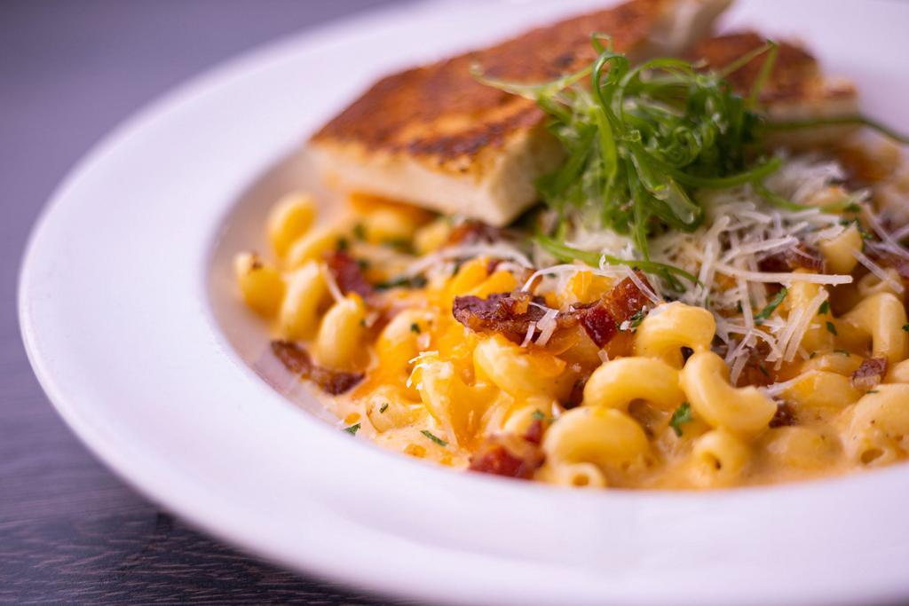 Mac & Cheese · The Mac & cheese is one of our most popular dishes, in which has Cavatappi pasta cooked with Tillamook cheddar cheese, Parmesan and chopped bacon, julienne green onions and crusted garlic toast as toppings.