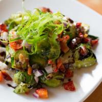 Roasted Brussels Sprouts · A mix of red peppers, onions, bacon and Brussels sprouts, sautéed to crisp bites, topped wit...