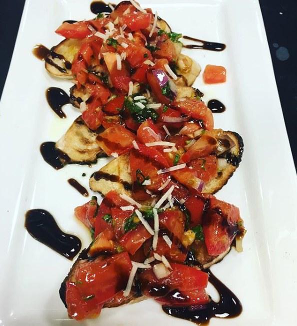 Brasserie Bruschetta · Toasted bread with tomatoes, basil, onion, and garlic topped with asiago, drizzled with olive oil and balsamic glaze.