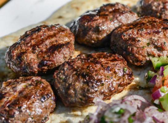 Kofte Kebab · Char grilled ground lamb patties seasoned with Turkish spices and served over rice and salad.