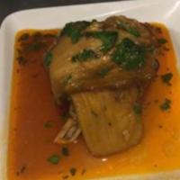 Lamb Shank · Delicious baked soft lamb on a bone wrapped with eggplant and marinated in red tomato sauce. 