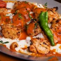 Yogurtlu Chicken Kebab · Char grilled chunks of chicken breast served with yogurt and tomato garlic sauce over pita b...