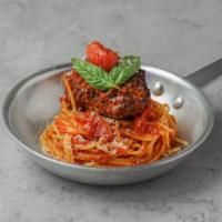 Spaghetti and Homemade Meatball · Spaghetti with tomato sauce and a large homemade meatball.