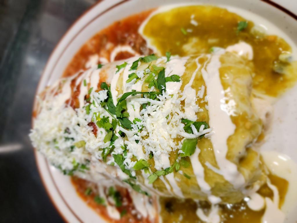 Jose's Mariachi Burrito · Steak, chicken, shrimp, rice, charro beans, cabbage, avocado, cheese, and pico de gallo. ROlled and topped with three Mexican salsas: queso, verde, and molcajete red. Garnished with cilantro, queso fresco and sour cream.
