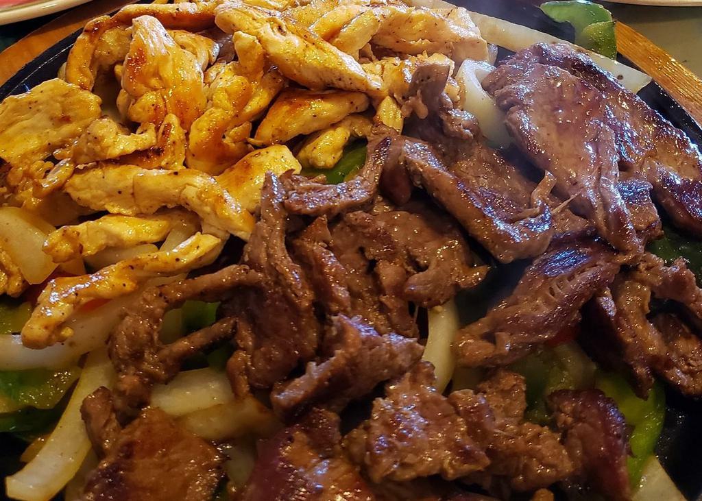 Fajitas Mixed (steak and chicken) · Grilled steak and chicken with onions and peppers. Served with rice, choice of refried or black beans, side of lettuce with sour cream, tomatoes, guacamole, and three flour tortillas.