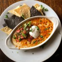 Queso Fundito · Cheddar and mozzarella cheese baked over a New Mexico chorizo red chili topped with pico de ...