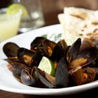 Guajillo Mussels · Fresh Canadian mussels steamed in our signature red Chile citrus wine broth with fresh basil...