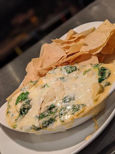 Creamed Spinach Dip · Sauteed spinach and artichoke hearts in a creamy cheese sauce, served with corn tortilla chips.