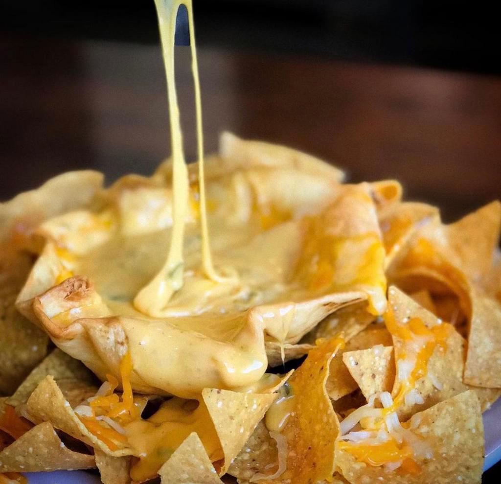 Adrian's Chile con Queso · Homemade flour tortilla bowl, queso made from 5 different cheeses, New Mexico green chile, onions, garlic, jalapenos use caution. Very addicting!