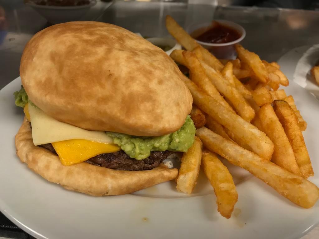 Arellana's Guaca Sopapilla Burger · Fresh Angus, chuck ground steak, served with 2 melted slices of American cheese, guacamole, between 2 freshly made sopapillas. Absolutely marvelous!
