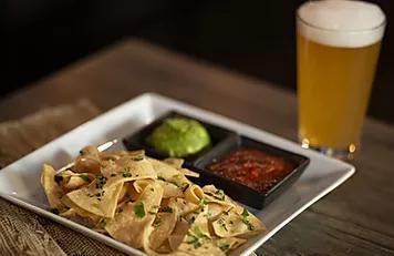 Chips & Guacamole · Corn tortilla chips topped with fresh cilantro, sides of guacamole and roasted tomato salsa.